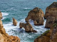 Wellen branden gegen die Felstürme an der Ponta da Piedade